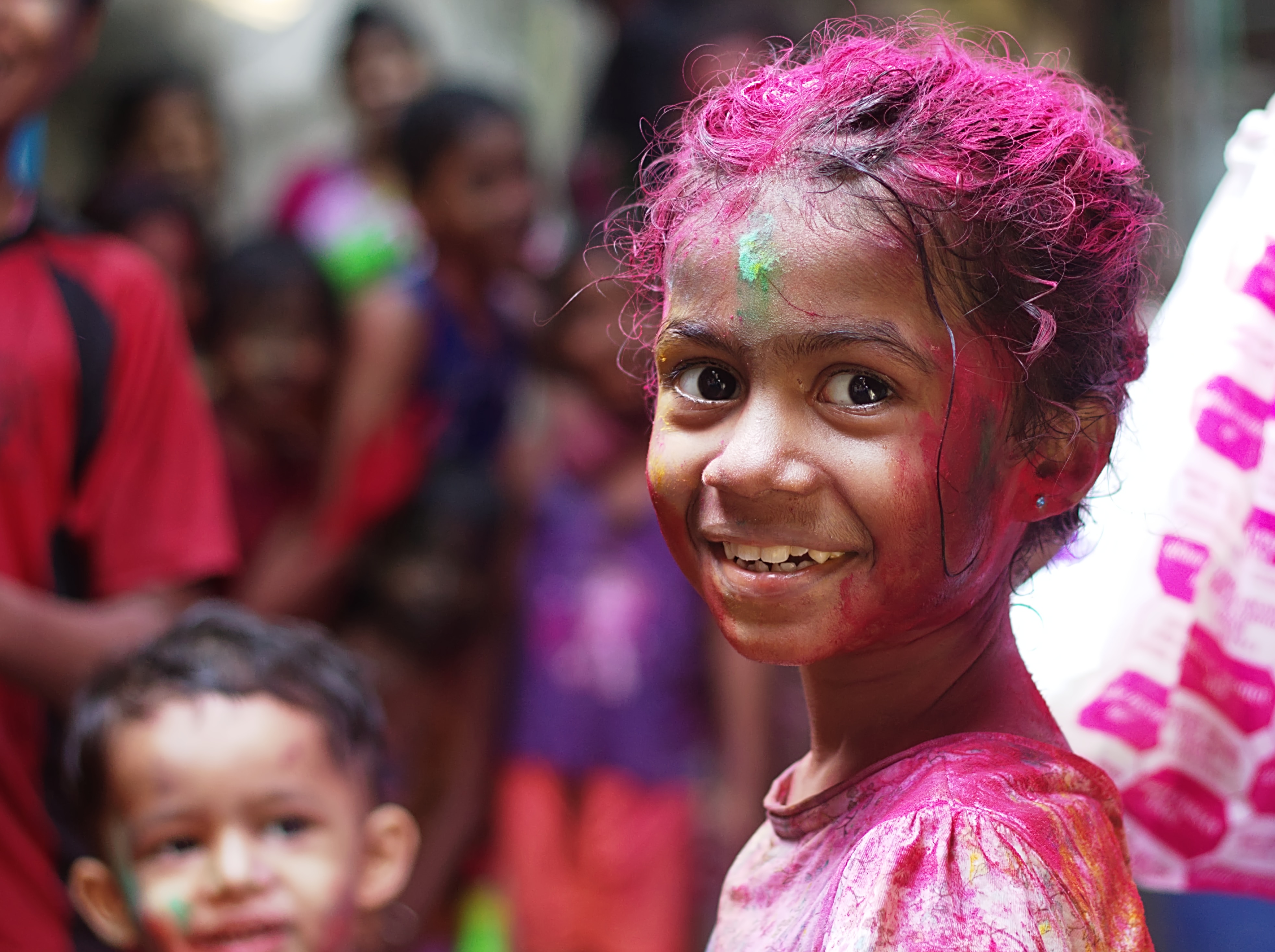 Girl smiling presumably celebrating Holi with color dyes on her