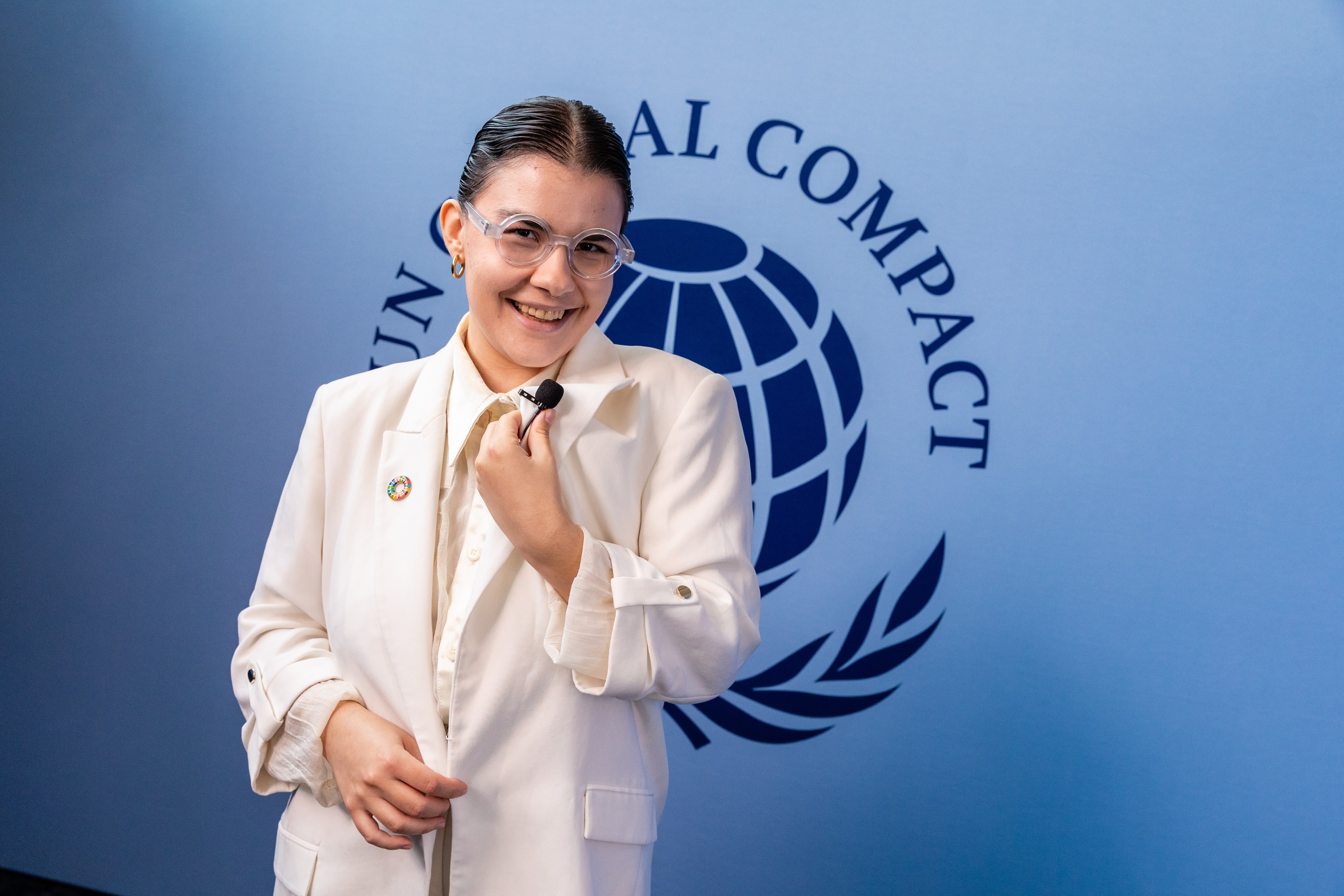 Luísa Franco Machado in front of UN Global Compact sign SDG pin